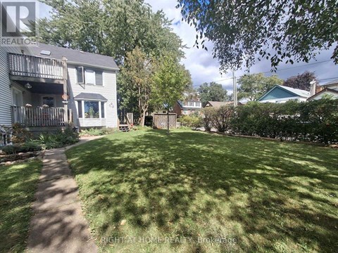 A backyard with a lawn and a tree.