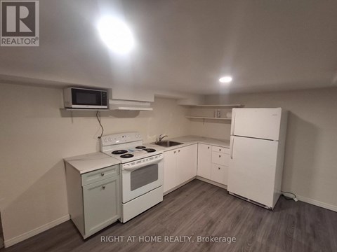 A small kitchen with a white fridge and stove.