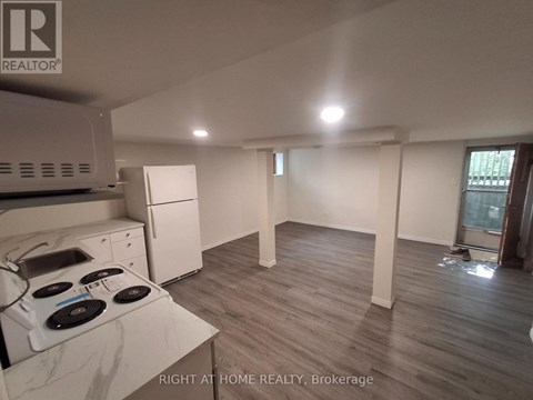 A kitchen with a stove top oven and a refrigerator.