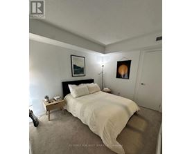 A bedroom with a bed, nightstand, and lamp.