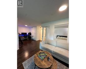 A living room with a couch, a coffee table, and a television.