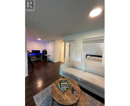 A living room with a couch, a coffee table, and a television.