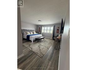 A bedroom with a bed, bench, and a rug.