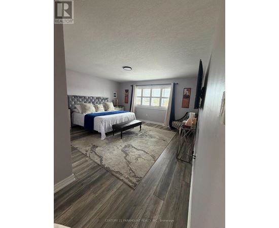A bedroom with a bed, bench, and a rug.