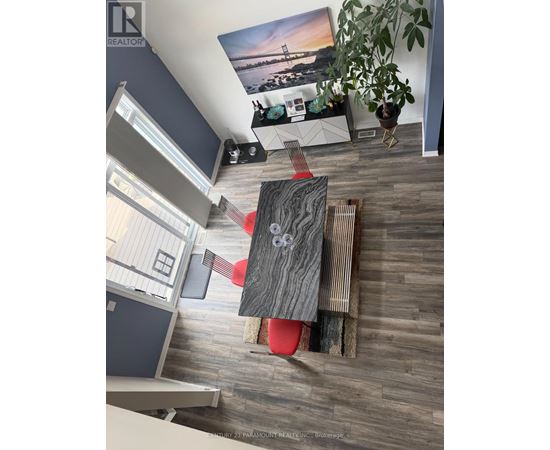 A living room with a grey wooden floor and a red chair.