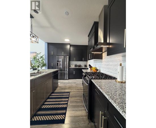 A modern kitchen with black cabinets and a granite countertop.