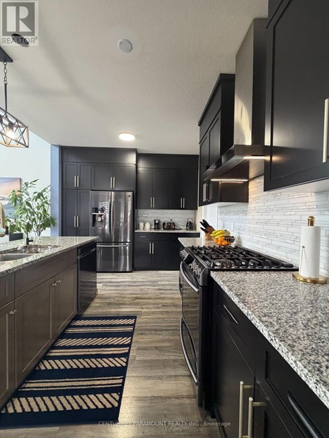A modern kitchen with black cabinets and a granite countertop.