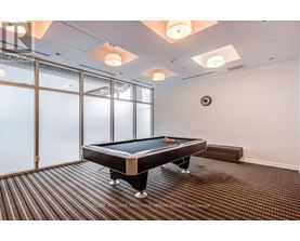 A pool table in a room with a clock on the wall.