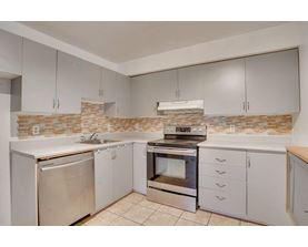 A kitchen with a stove, oven, and refrigerator.