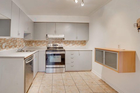 A kitchen with white cabinets and a tiled backsplash.