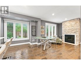 A dining room with a fireplace and a glass table.