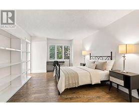 A bedroom with a bed, nightstand, and lamp.