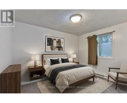A bedroom with a bed, nightstands, and a chair.