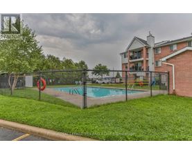 A pool surrounded by a black fence with a red life preserver.