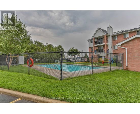 A pool surrounded by a black fence with a red life preserver.