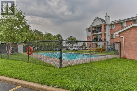 A pool surrounded by a black fence with a red life preserver.