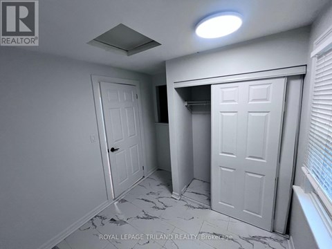 A white door is in a room with a marble floor.
