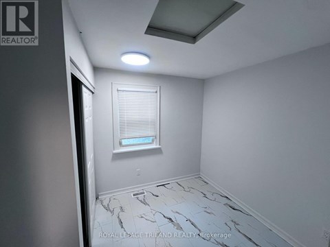 A room with a marble floor and a window with blinds.