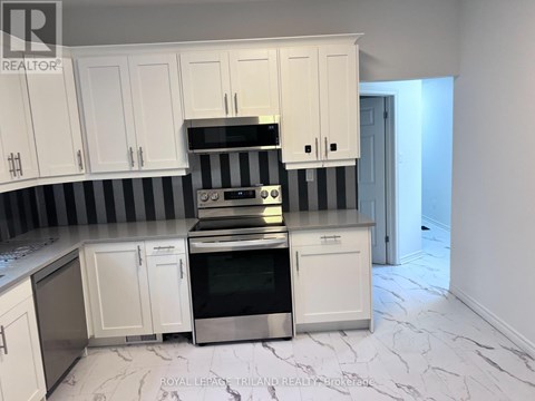 A kitchen with white cabinets and a black and white striped backsplash.