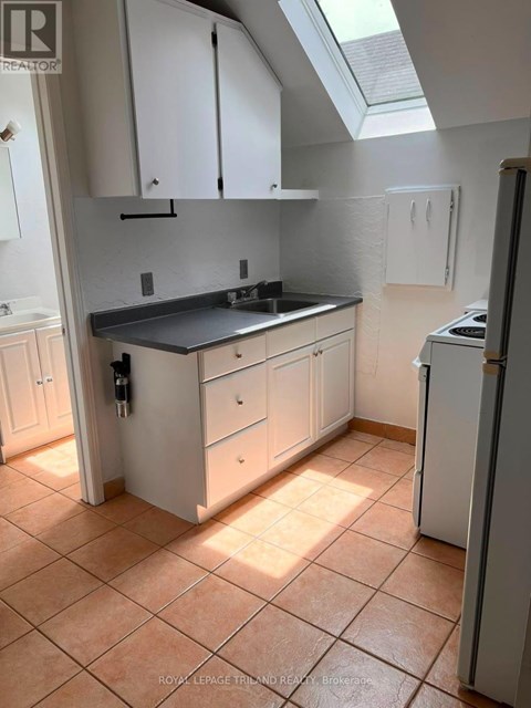 A kitchen with white cabinets and a black countertop.