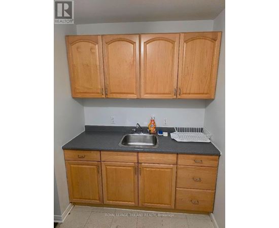 A kitchen with wooden cabinets and a sink.