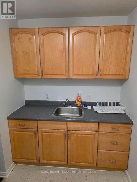 A kitchen with wooden cabinets and a sink.