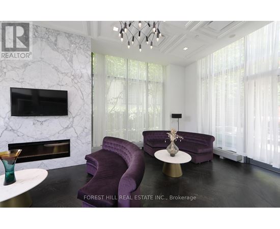 A living room with a purple couch and a fireplace.