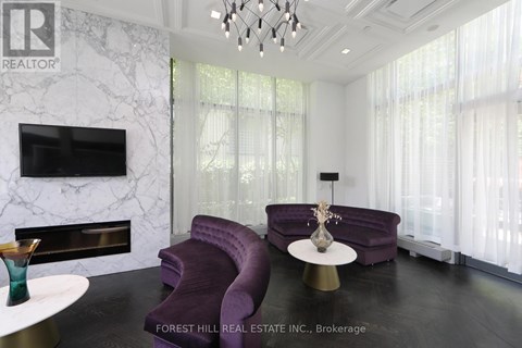 A living room with a purple couch and a fireplace.