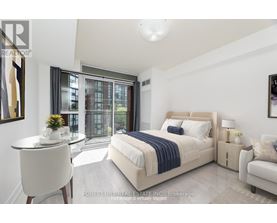 A bedroom with a large bed and a balcony with a view of a building.