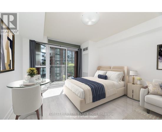 A bedroom with a large bed and a balcony with a view of a building.