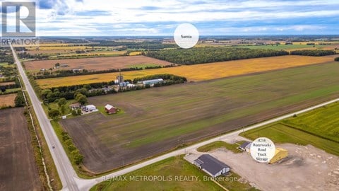 An aerial view of a rural area with a REMAX METROPOLIS REALTY sign.