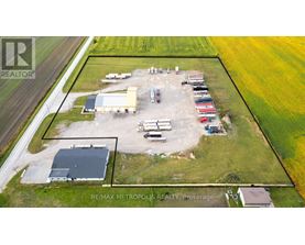 An aerial view of a farm with a large building and several vehicles.