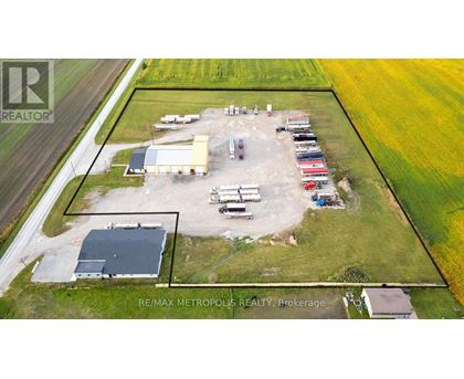 An aerial view of a farm with a large building and several vehicles.