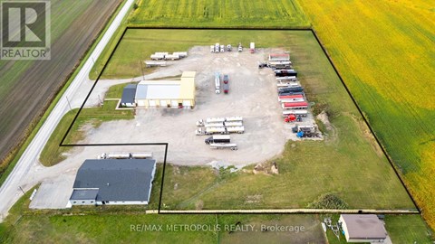 An aerial view of a farm with a large building and several vehicles.