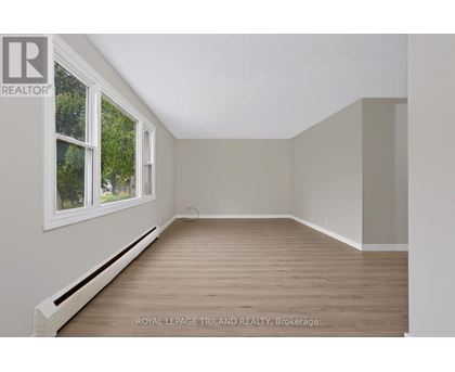 A room with a window and wooden flooring is available for rent.