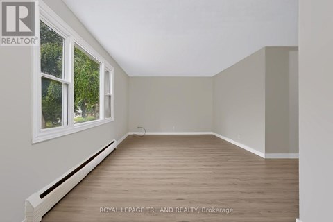 A room with a window and wooden flooring is available for rent.