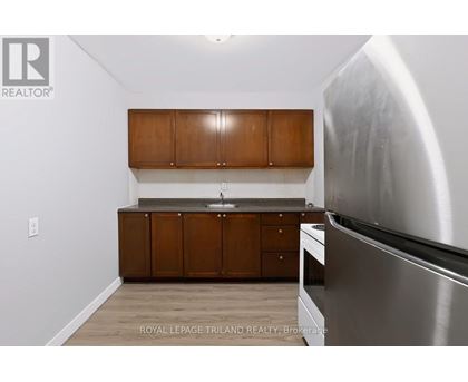 A kitchen with wooden cabinets and a stainless steel refrigerator.