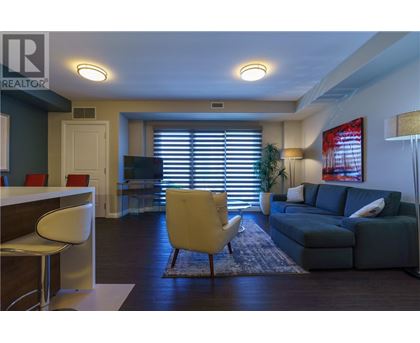 A living room with a yellow chair and a grey couch.