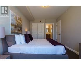 A bedroom with a large bed and a painting on the wall.