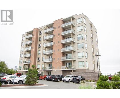 A large apartment building with a parking lot in front.