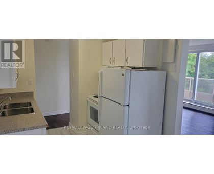 A white refrigerator in a kitchen with a sink and a window.