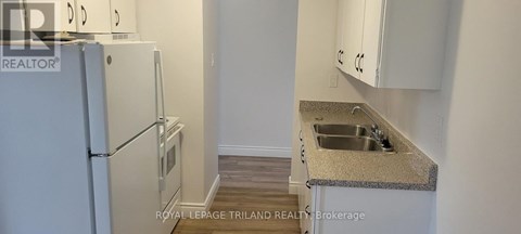 A kitchen with a sink and a refrigerator.