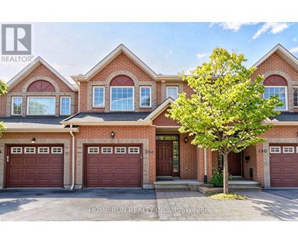 A large brick house with a tree in front and a sign that says "HOME RUN REALTY INC Brokerage".