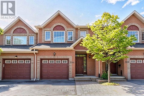A large brick house with a tree in front and a sign that says "HOME RUN REALTY INC Brokerage".