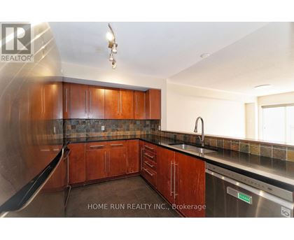 A kitchen with wooden cabinets and a stainless steel dishwasher.