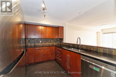 A kitchen with wooden cabinets and a stainless steel dishwasher.