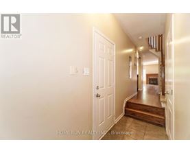 A hallway with a white door and a logo on the wall.