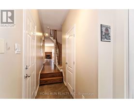 A hallway with a wooden floor and white walls.