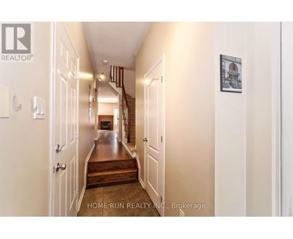 A hallway with a wooden floor and white walls.