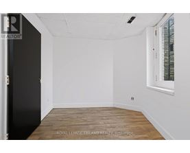 A white room with a black door and a window with a white frame.
